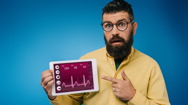 bearded man pointing at a screen with health data