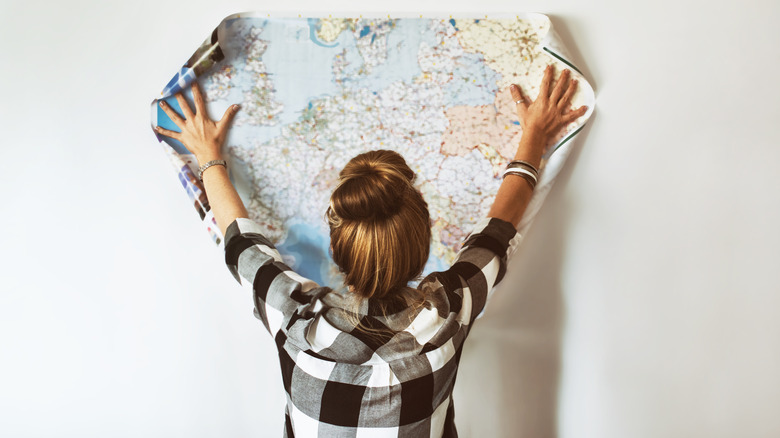 Woman spreading map on wall