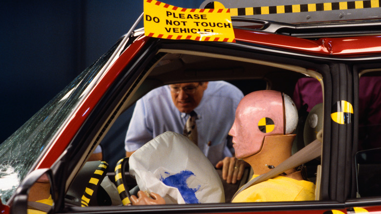 Person inspecting crash test dummy