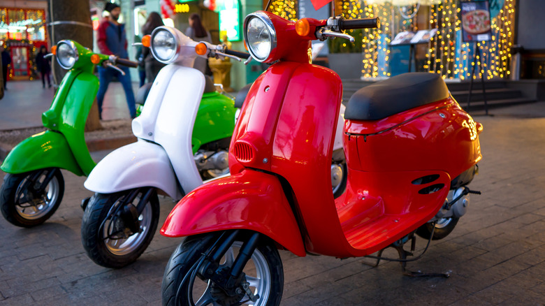 Three vintage scooters parked.