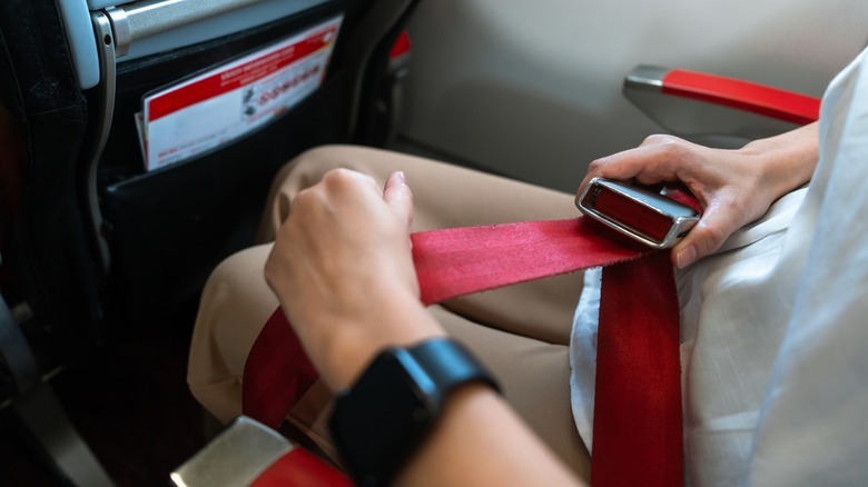 passenger putting on seatbelt