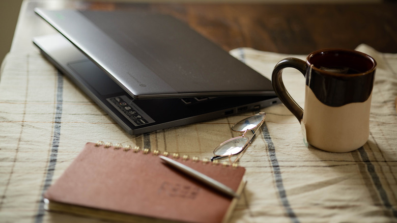 Acer laptop next to journal, tea, glasses