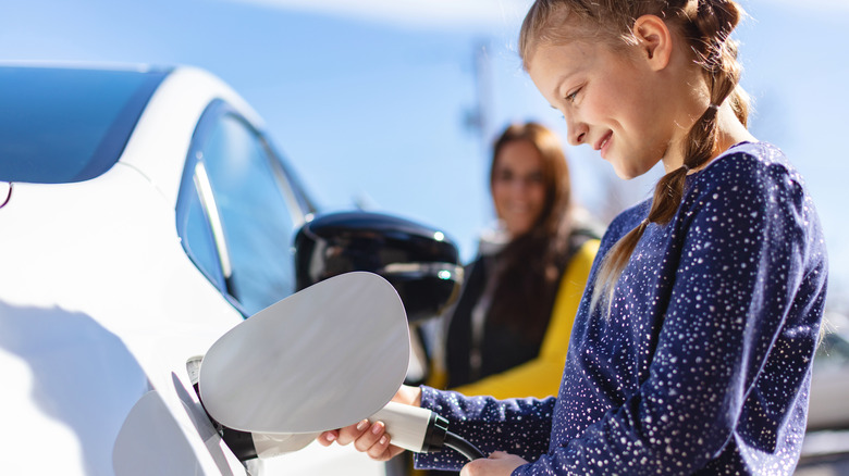 young girl charging an electric car