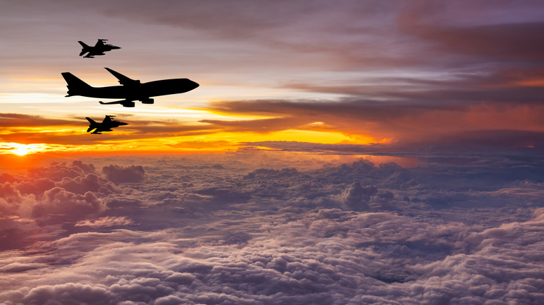 Air Force One flying into sunset with fighter escort