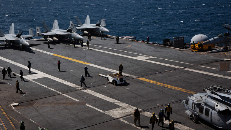 Navy ship flight deck with aircraft and personnel on deck