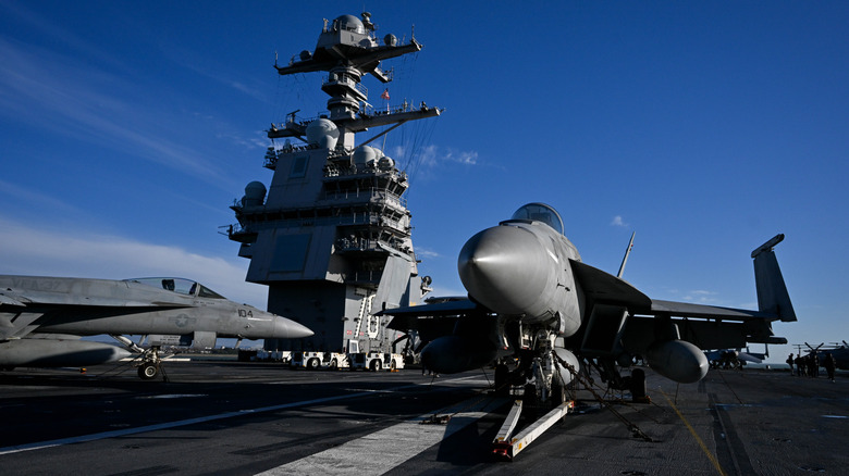 Closeup of front end of jet on an aircraft carrier flight deck