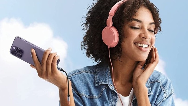 A woman listening to music with the UGREEN adapter.