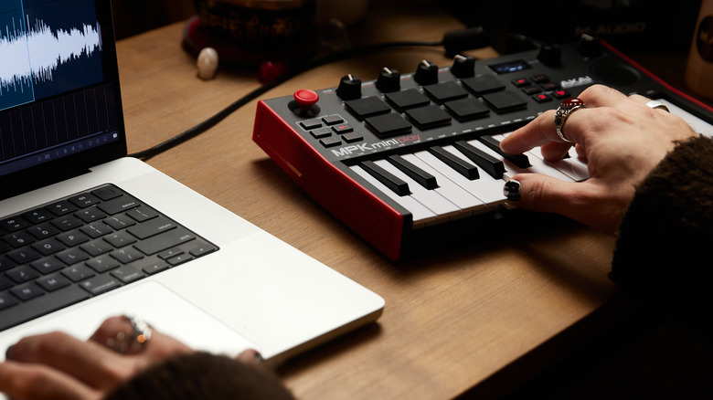 Musician using Akai Mini Play MK3 MIDI keyboad with 16-inch MacBook Pro M1 Max
