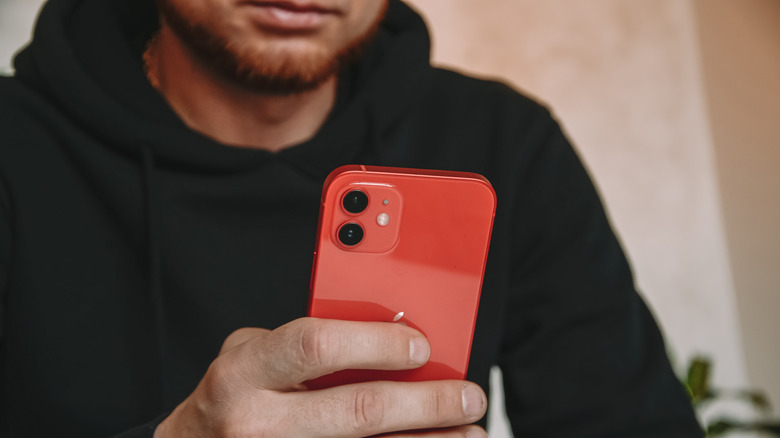 Man holding (PRODUCT)RED iPhone