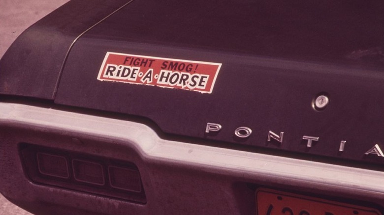 A Pontiac with a bumper sticker that reads "Fight Smog! Ride a Horse"