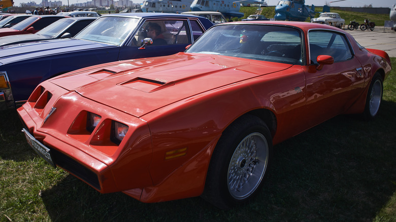 Red 1979 Pontiac Firebird parked on grass