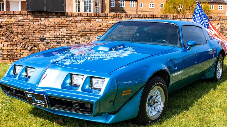 Blue 1979 Pontiac Firebird Trans Am on display with American flag