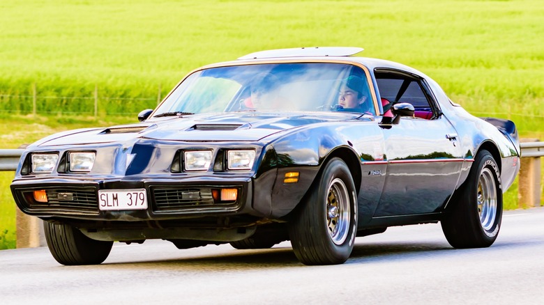 Black 1979 Pontiac Firebird Formula driving on a roadway