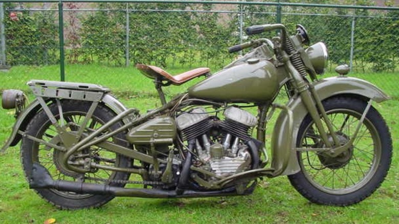 A World War II-era Harley-Davidson WLA motorcycle parked on grass.