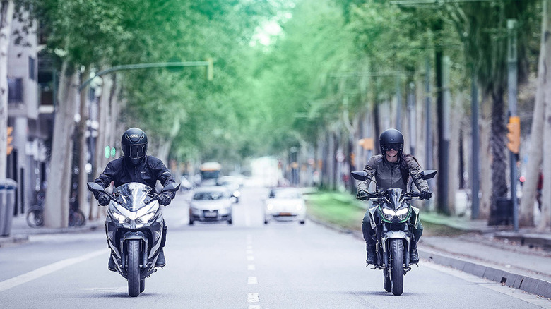 people riding kawasaki e-1 bikes