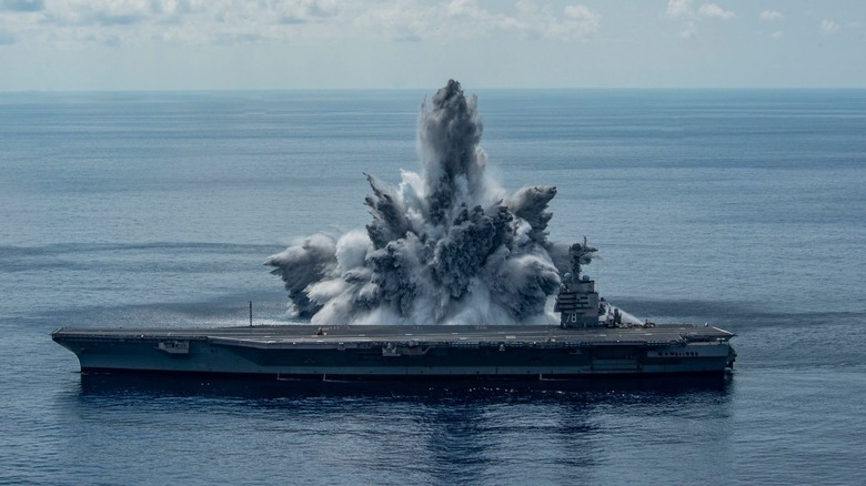 USS Gerald R. Ford with eruption behind