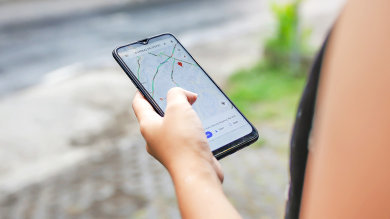 Woman using Google Maps app on smartphone