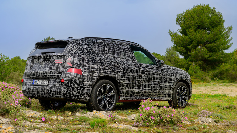 Rear 3/4 view of camouflaged BMW X3