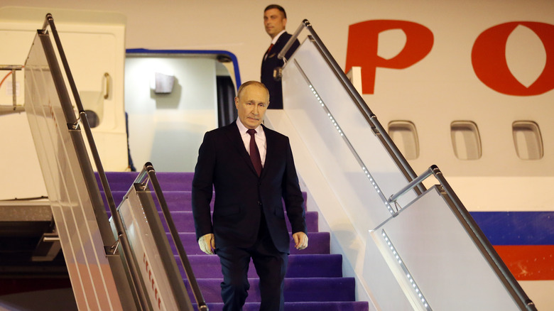 Putin walking down from stairway.