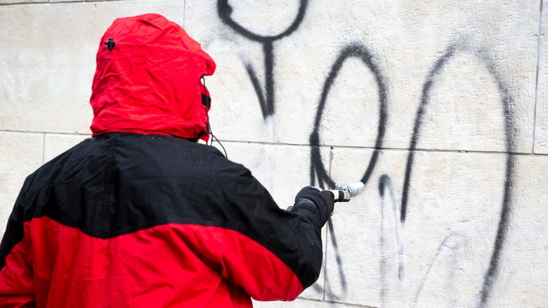 Sand blasting graffiti off a wall