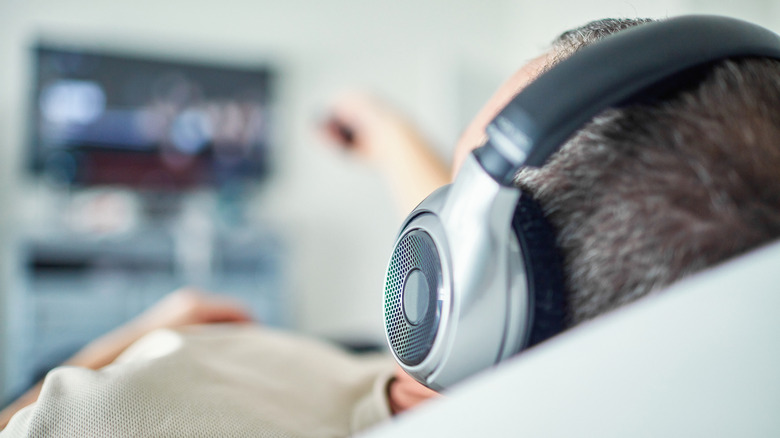 man watching TV with headphones