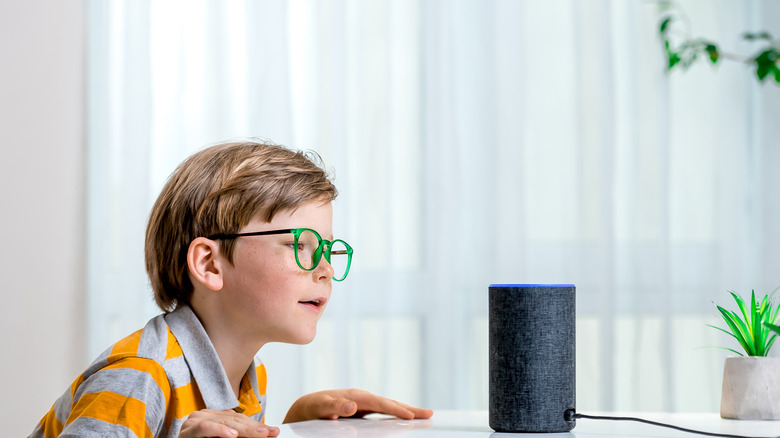 boy next to Alexa speaker