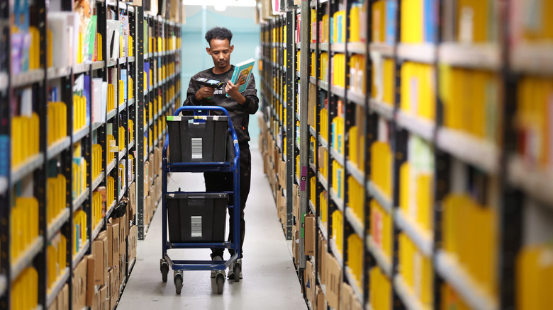 Amazon fulfillment center employee pulling products off shelves