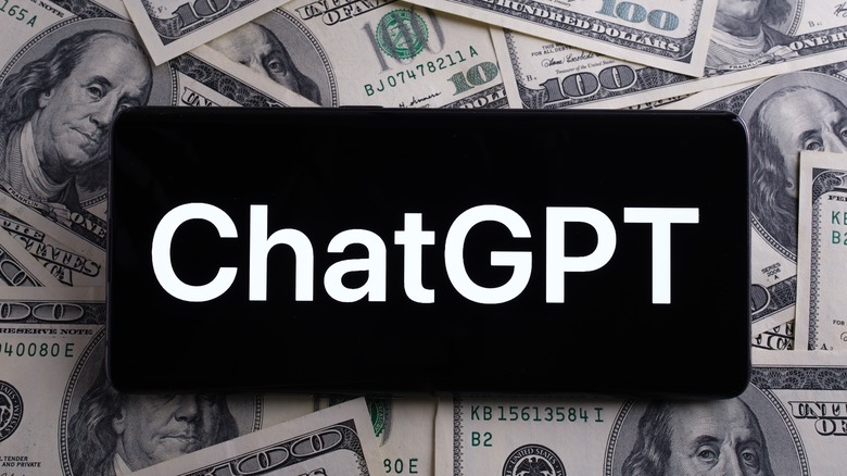 Phone with "ChatGPT" text over dollar bills 