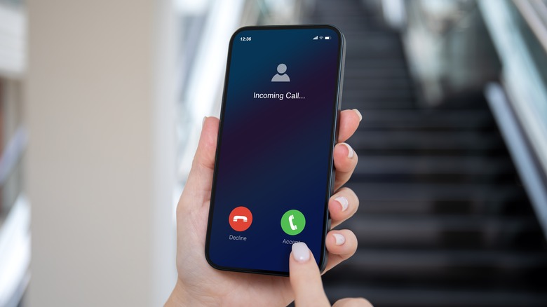 Woman hands hold phone with incoming call on screen