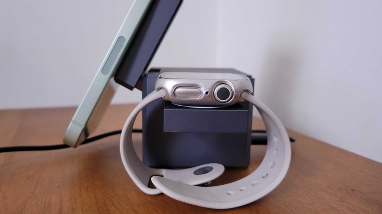 A side view of an Apple Watch and iPhone 12 charging on the 3-in-1 cube