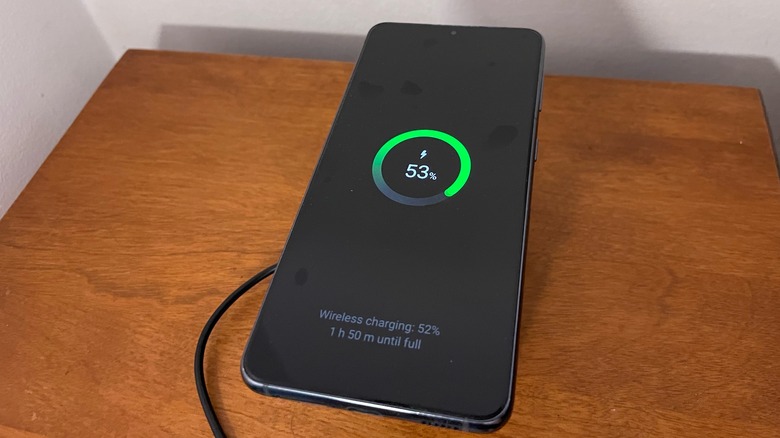 A Samsung phone wirelessly charging on Anker's cube