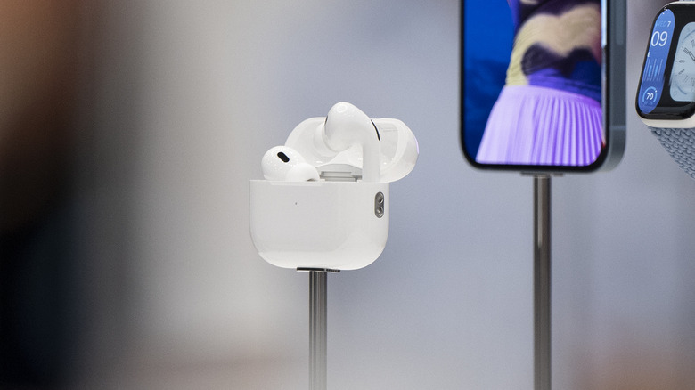 The second-gen AirPods Pro pictured with an iPhone and Apple Watch.