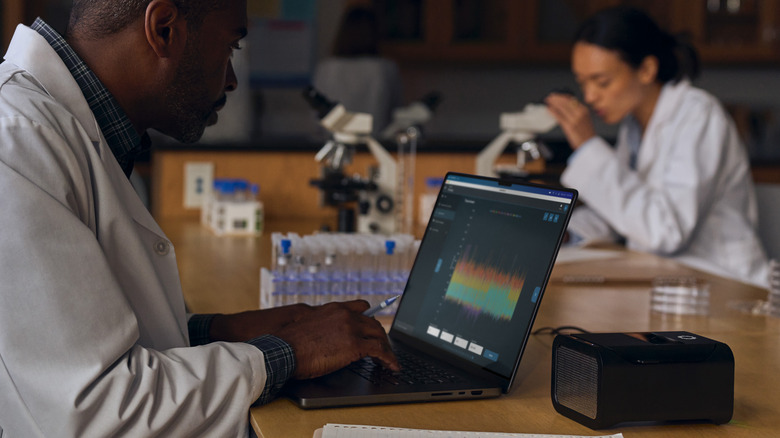 A scientist using an M4 Powered Apple MacBook Pro inside a lab