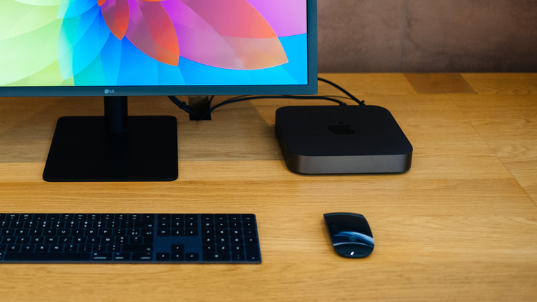 Mac mini on wood surface near LG monitor