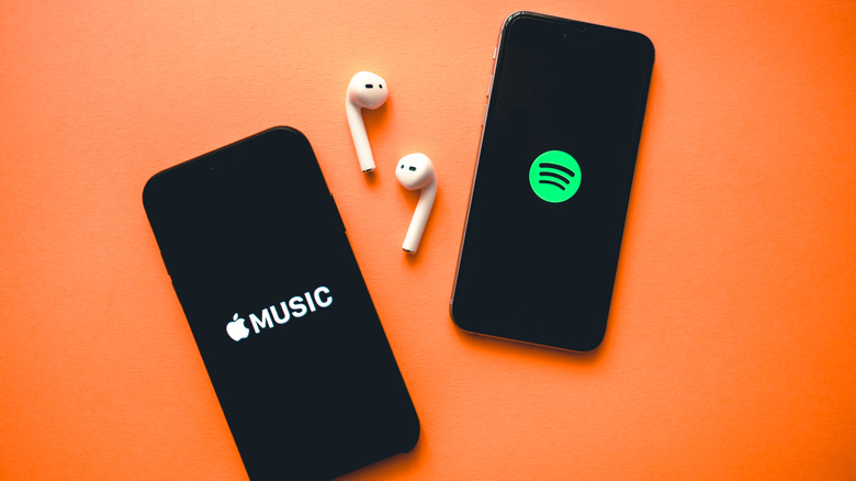 Apple Music, Spotify logos on two smartphones