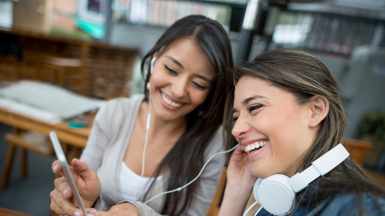 two friends listening to music with earphones