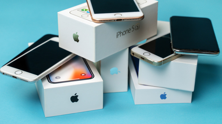 A pile of used iPhones and their boxes.