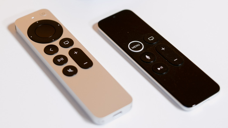 White and black Apple TV remotes on a white table