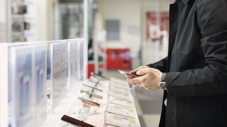 man looking at display phones