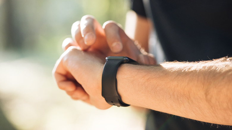 Man checking smartwatch outdoors