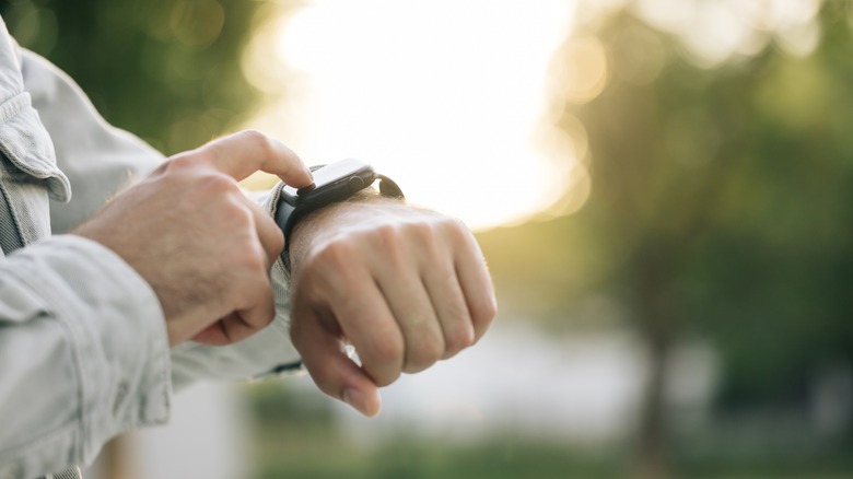 Person checking smartwatch outdoors