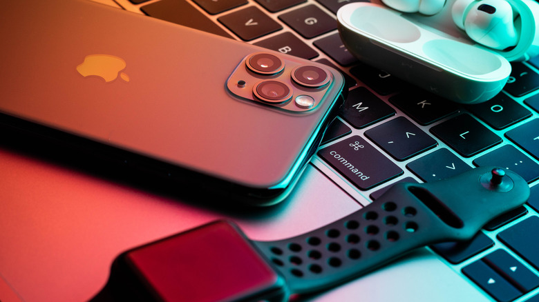 iphone, airpods, apple watch on a macbook keyboard