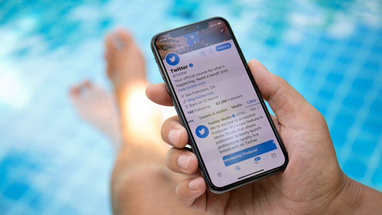 Man using iPhone by the pool