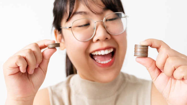 woman comparing two coin stacks