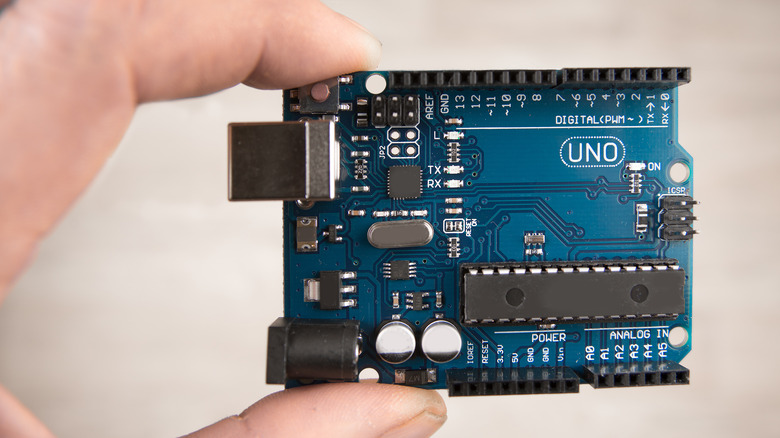 hand holding Arduino Uno