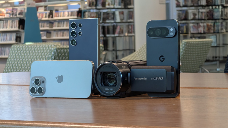 Three phones and a camcorder on a table