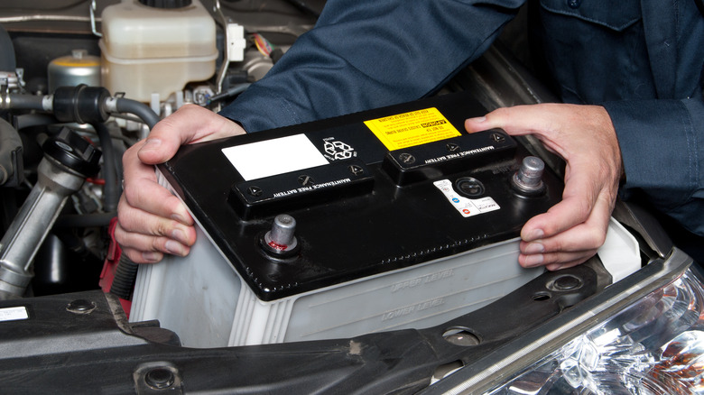 Mechanic installing car battery