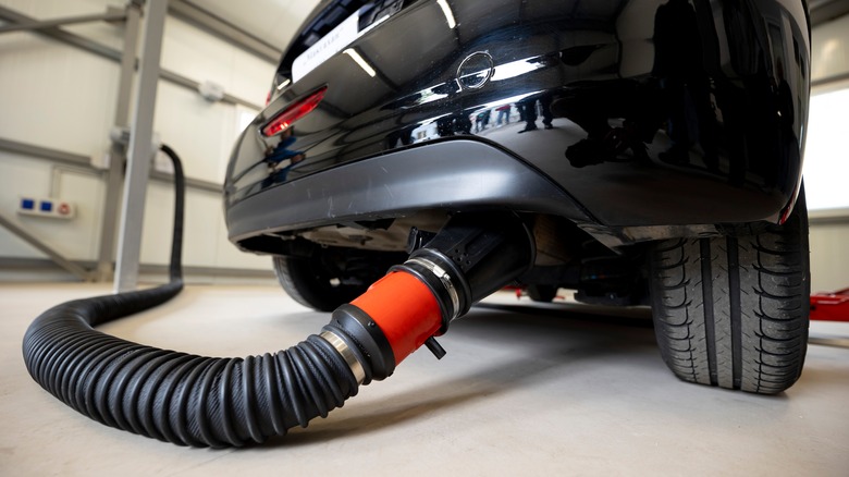 smog check on car exhaust pipe