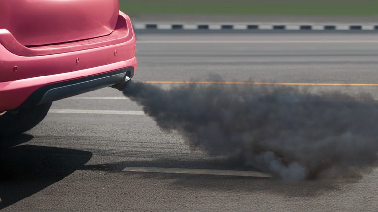 Diesel exhaust fumes from a red car.