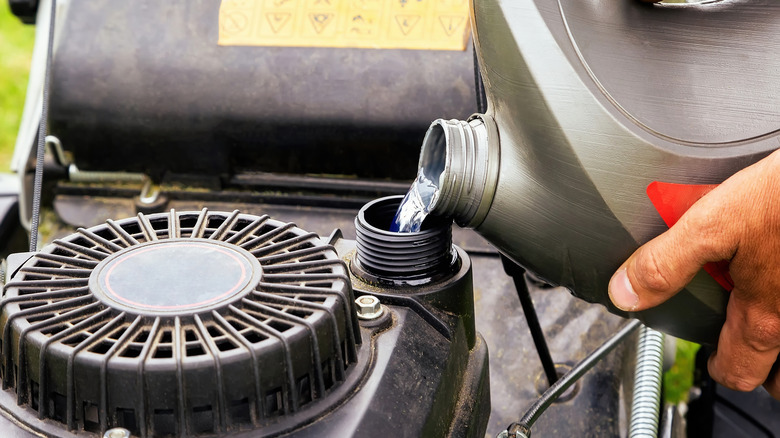 Pouring fuel into lawn mower tank